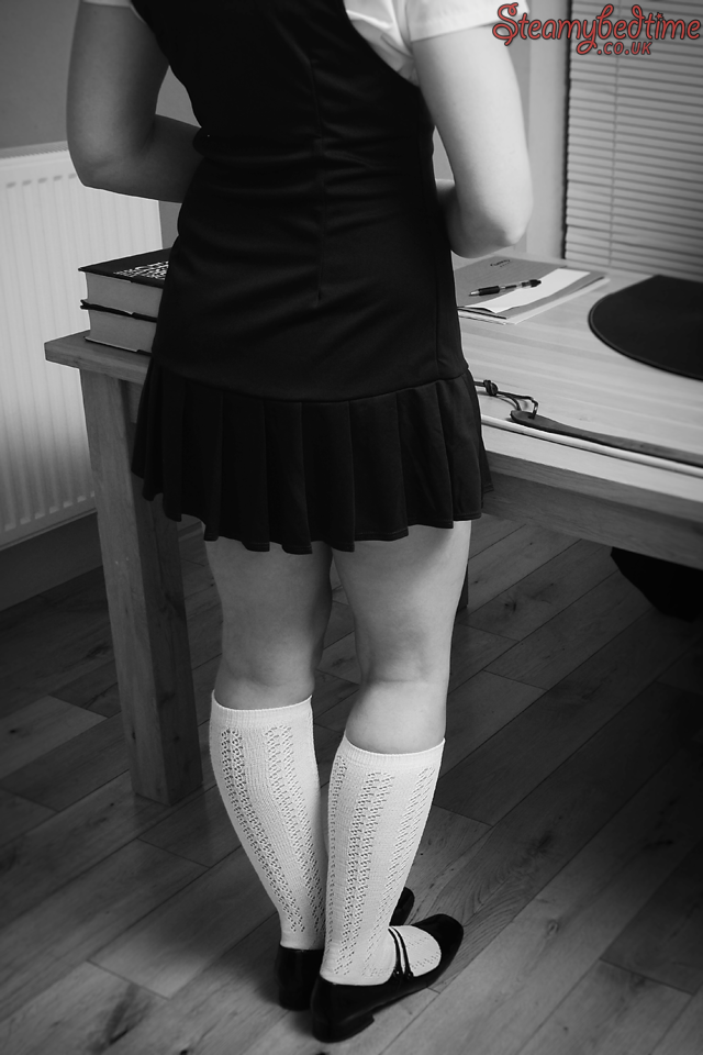 Role play schoolgirl waiting nervously at the headmaster's desk.